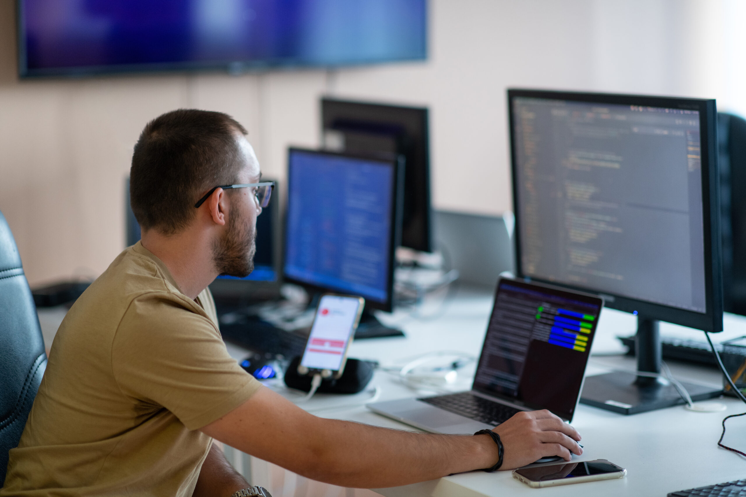 A programmer diligently testing smartphone applications while sitting in their office