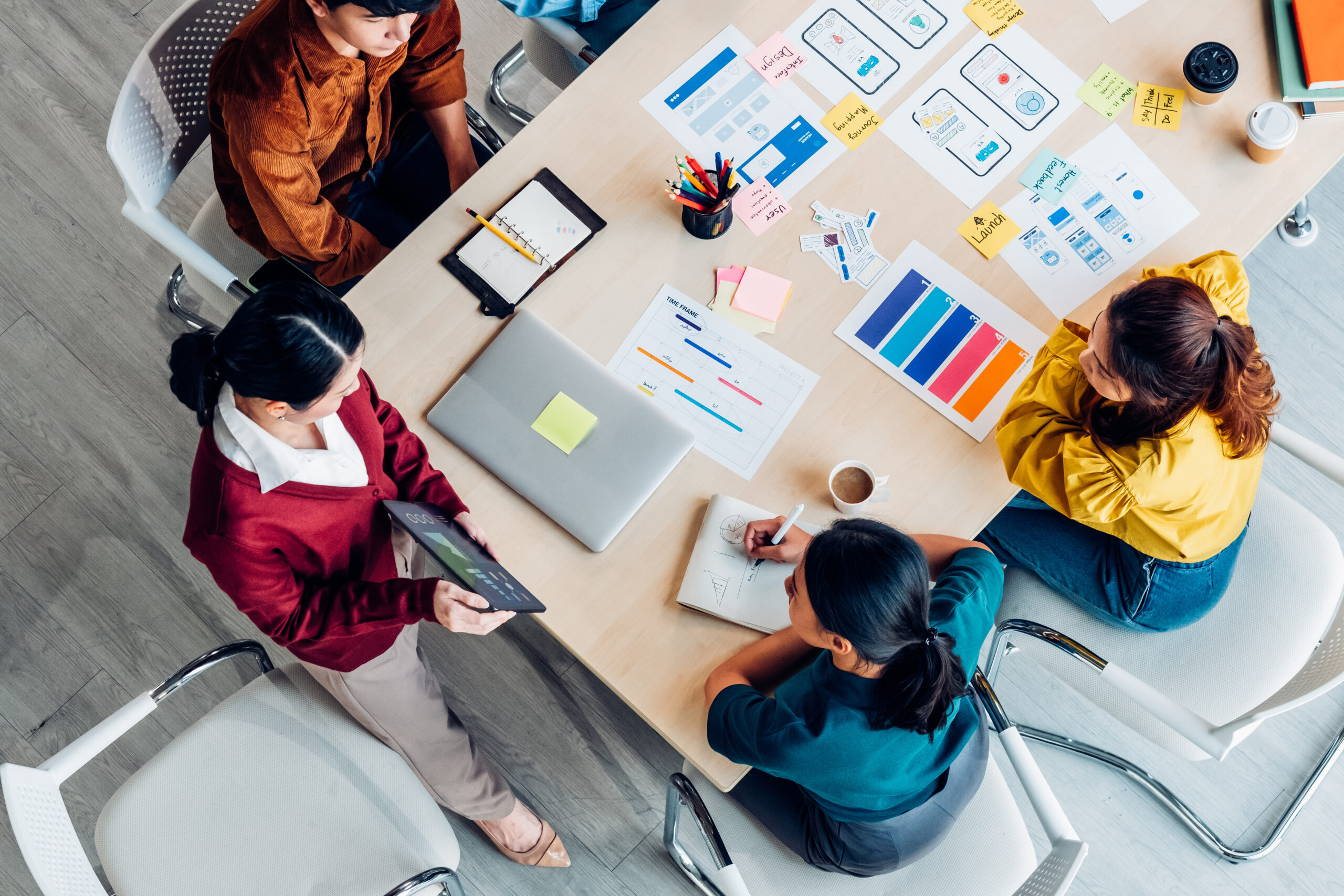 top view ux developer and ui designer presenting mobile app interface with success growth income graph on tablet in meeting at modern office.Creative digital development mobile app agency