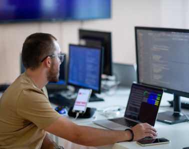 A programmer diligently testing smartphone applications while sitting in their office