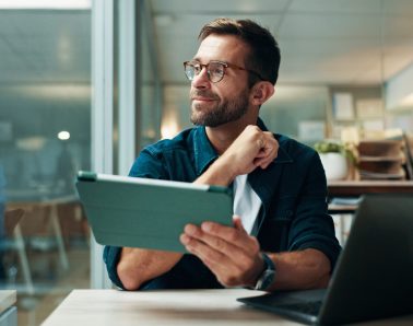 Tablet, thinking and smile with business man in office for planning, ui designer and app review. Developer solutions, reflection and research with person in agency for project idea and startup.